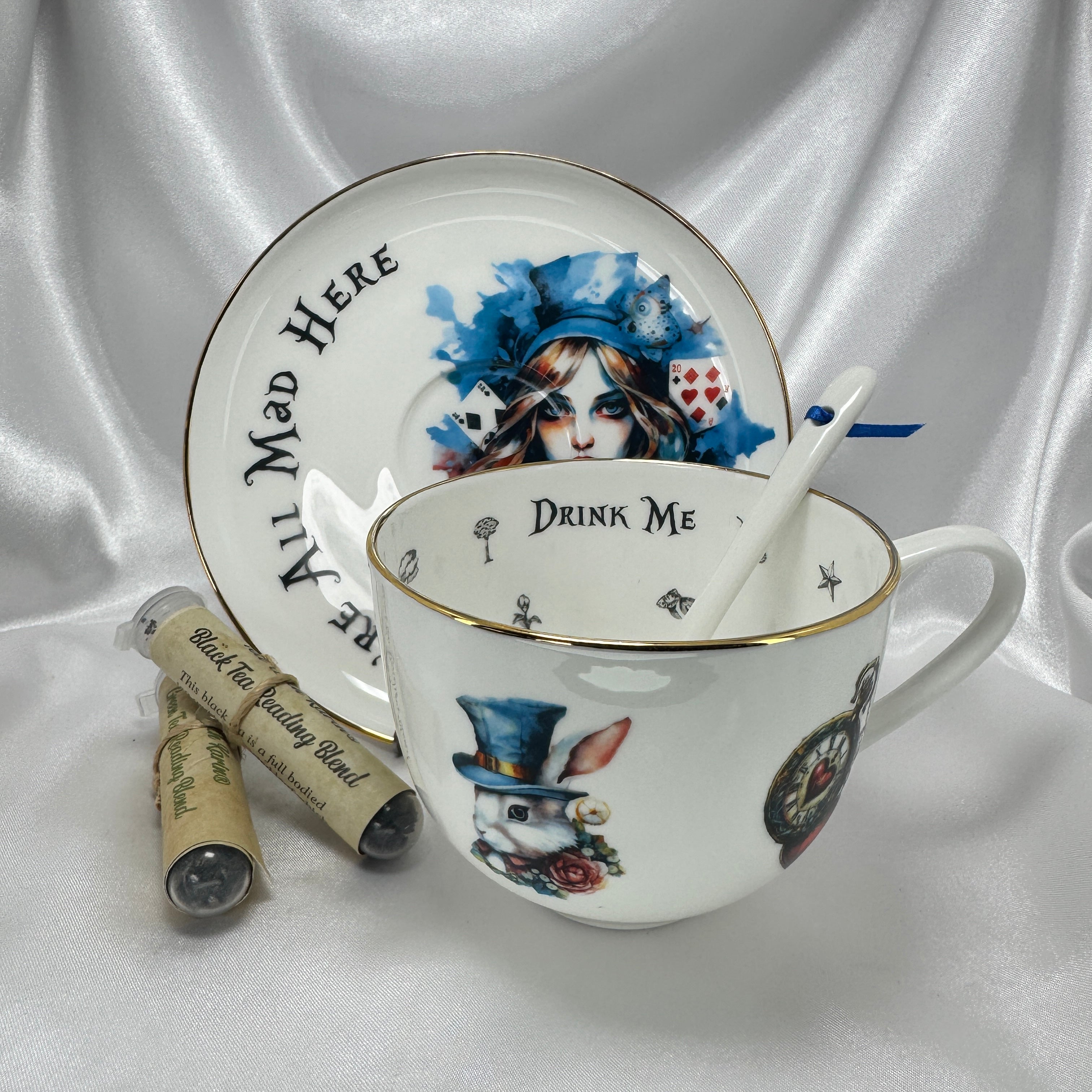 Teacup set with 'Drink Me' and 'Alice in Wonderland' design on a white satin background