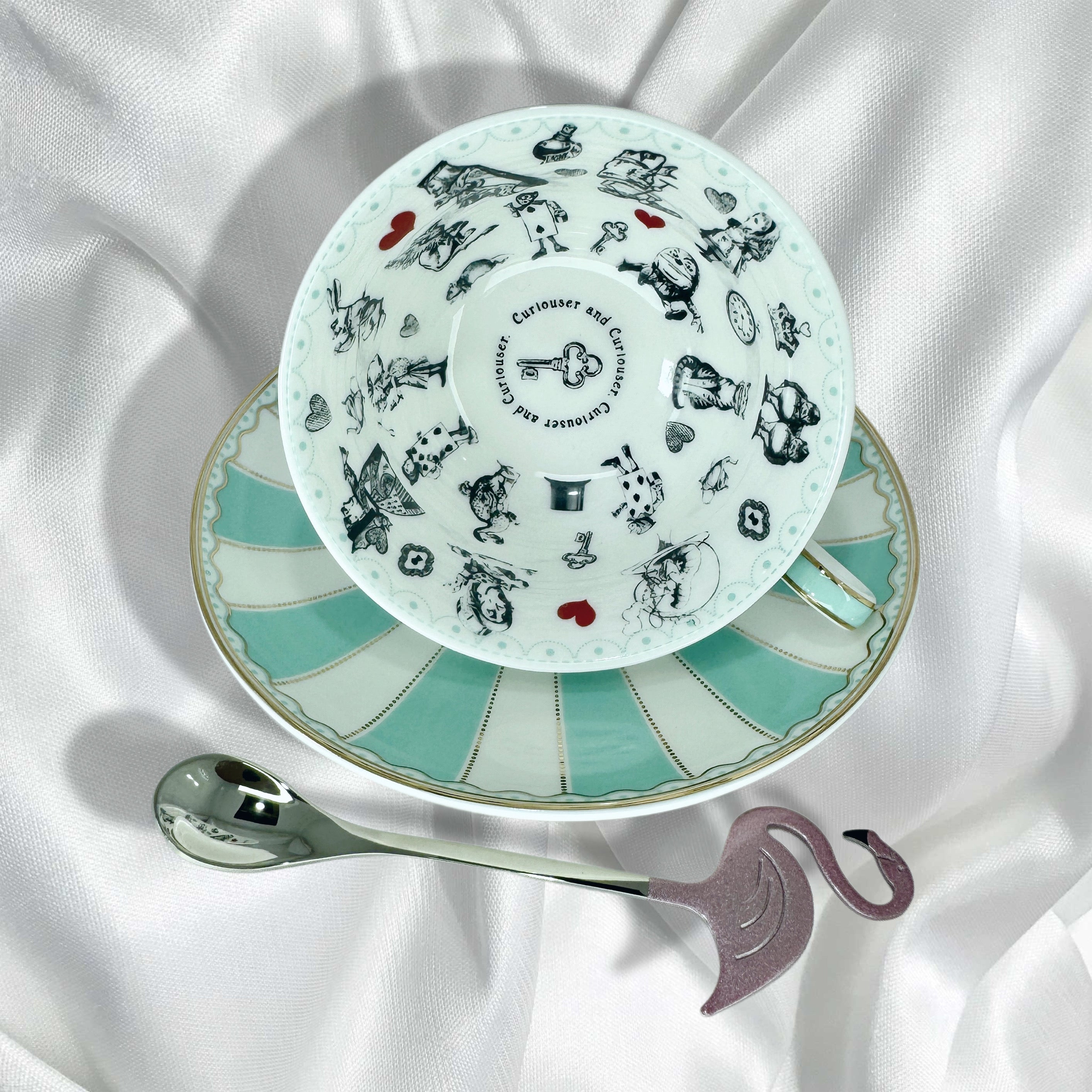 Teacup showing the black and white Alice in Wonderland illustrations inside for Tasseography or fortune
