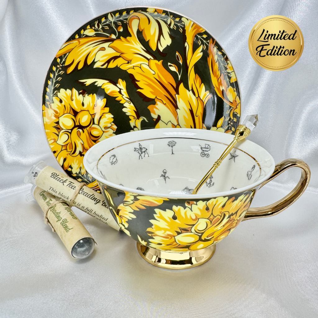 Black and gold fortune telling teacup and saucer set with gold teaspoon and two sample tea tubes