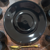 Jet black saucer with a gold crystal-topped teaspoon