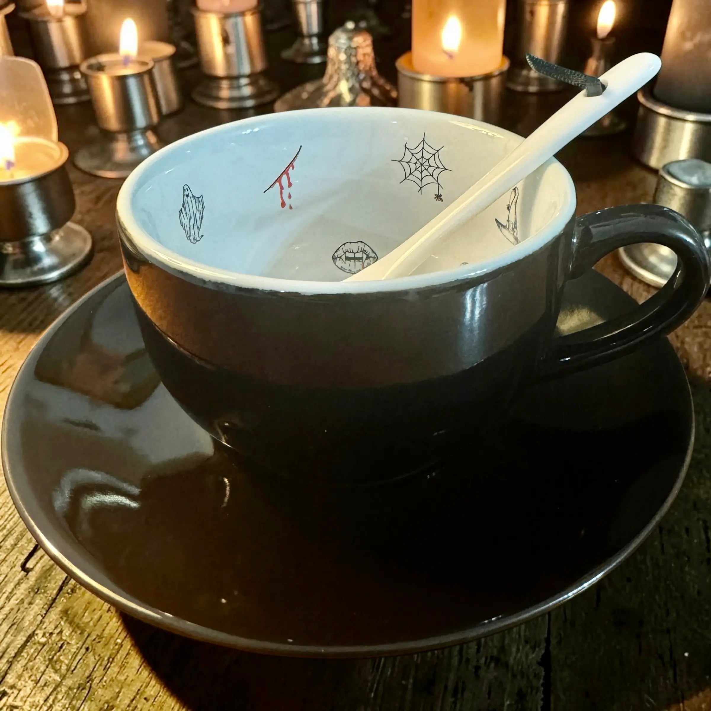 Jet black Halloween tea leaf reading teacup standing upright on its saucer