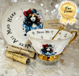 Whimsical Alice in Wonderland tea set with gold-accented teacup, saucer, and teaspoon, featuring vivid symbols inside the cup, perfect for tea leaf reading and divination
