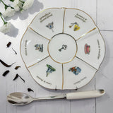 Labyrinth life wheel saucer with six illustrated sections and a 24ct gold rim, with a white-handled spoon
