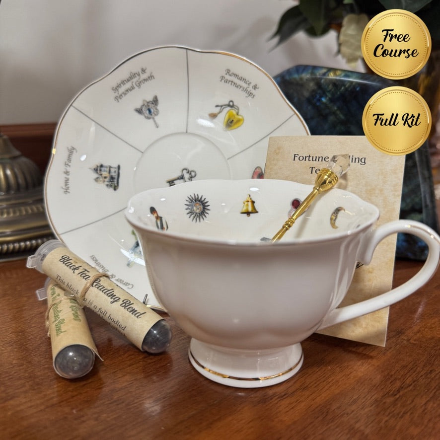Tea cup with saucer, tea leaves, and a gold spoon on a wooden surface.