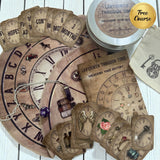 Vintage-style Labyrinth Through Time charm casting wheel mat for destiny readings. The circular mat is divided into life sectors (e.g., Money Matters, Home & Family, Love & Relationships) and displays the included antique-style divination cards and charm symbols.