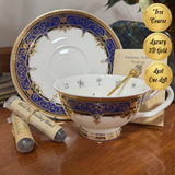 Decorative teacup and saucer with gold and blue detailing on a wooden surface.