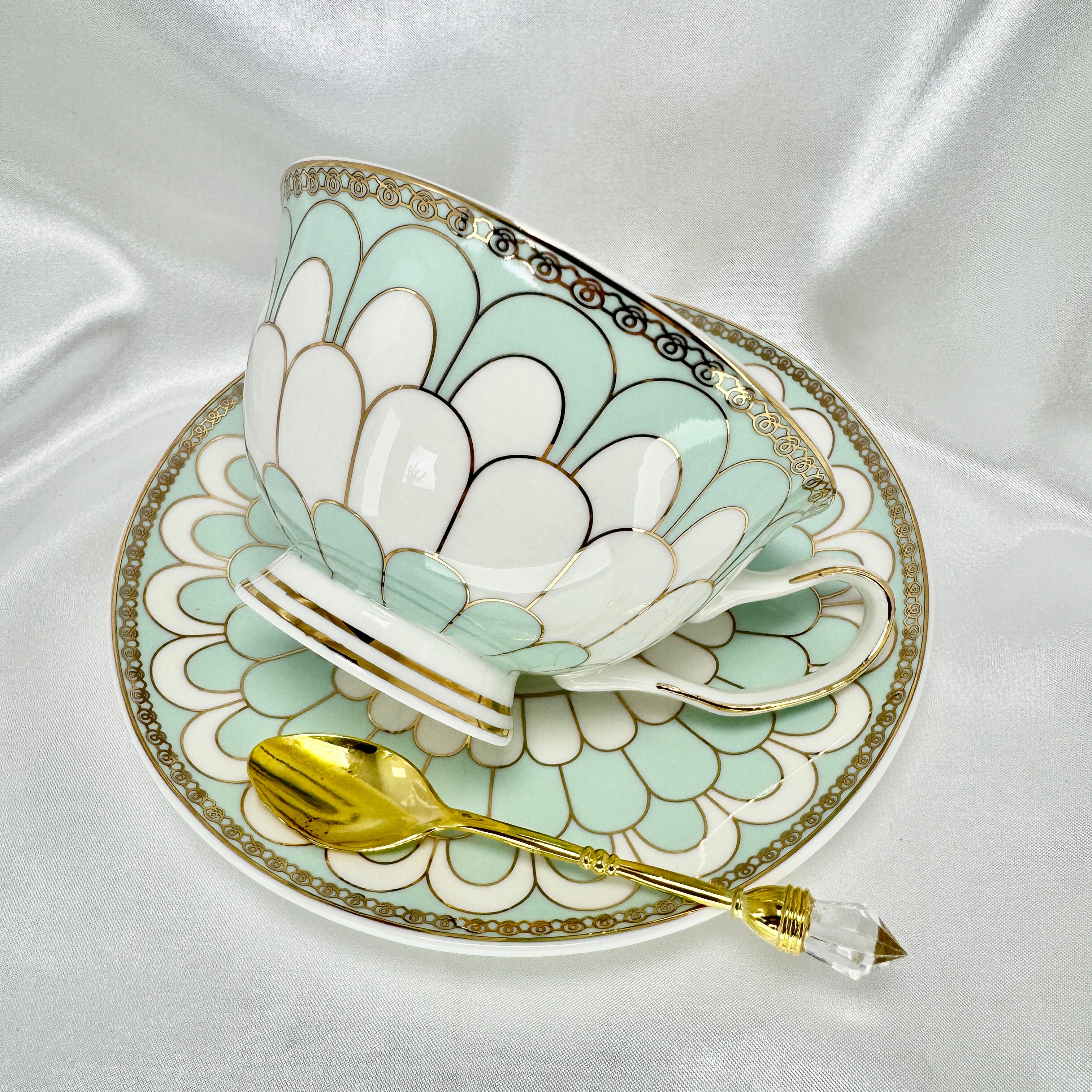 Right side view of the fortune telling teacup and saucer, featuring mint green and white exterior with gold detailing.