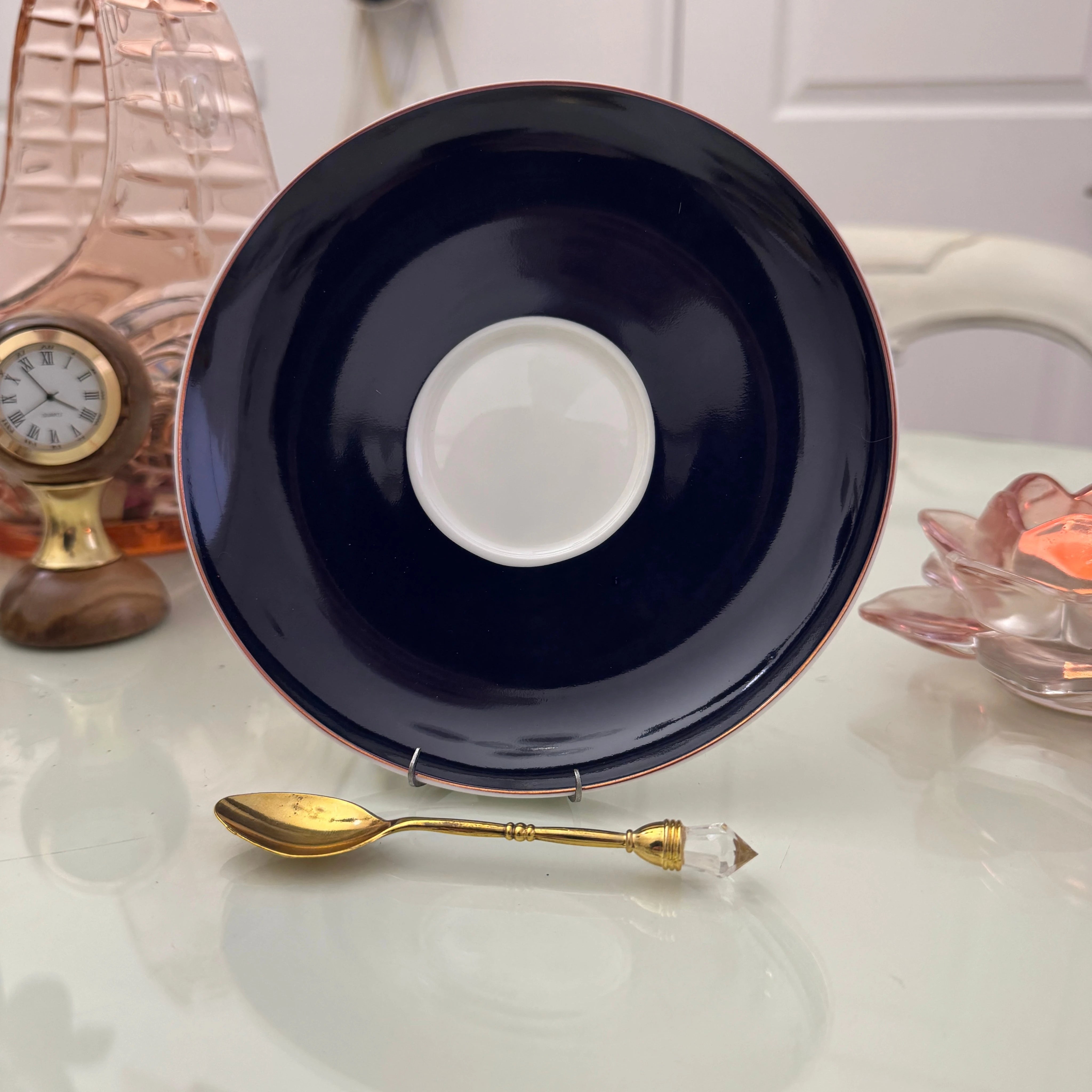 Peacock navy blue ceramic saucer with gold rim from tea leaf reading cup set, displayed with gold crystal teaspoon