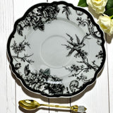 Stylish tea cup and matching saucer featuring embossed bird illustrations in black and white