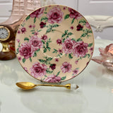 Pink butter rose floral ceramic saucer with gold rim from tea leaf reading cup set, displayed with gold crystal teaspoon