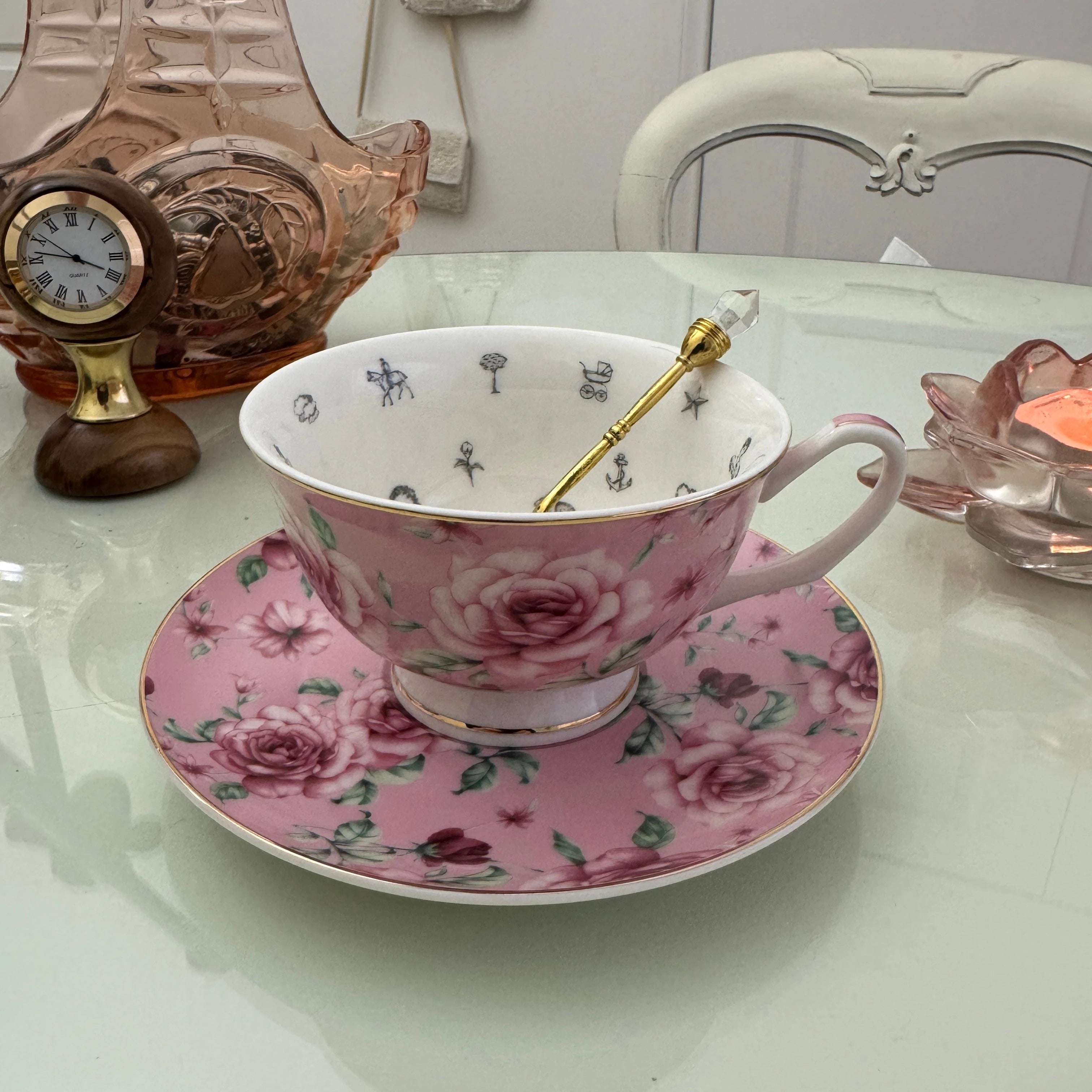 Pink rose floral tea leaf reading teacup and saucer set with gold crystal teaspoon, upright view showing divination symbols inside cup