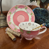 Decorative teacup with saucer and spoon on a wooden surface with tea packaging.