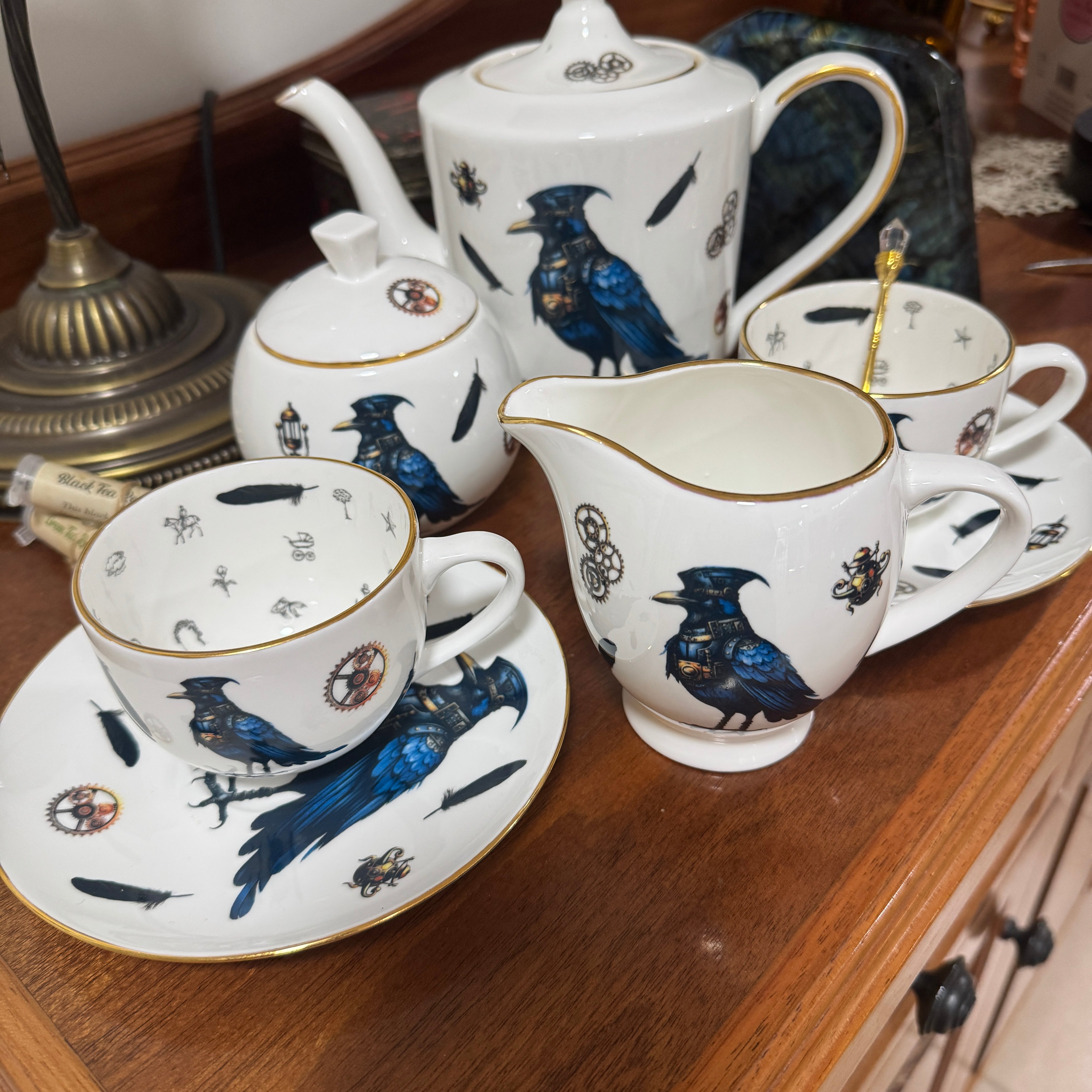Tea set with bird designs on a wooden surface