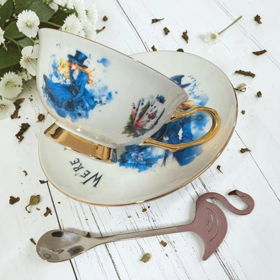 Side view of the Alice teacup showing Alice in blue watercolour, 24ct gold handle and foot, with flamingo teaspoon