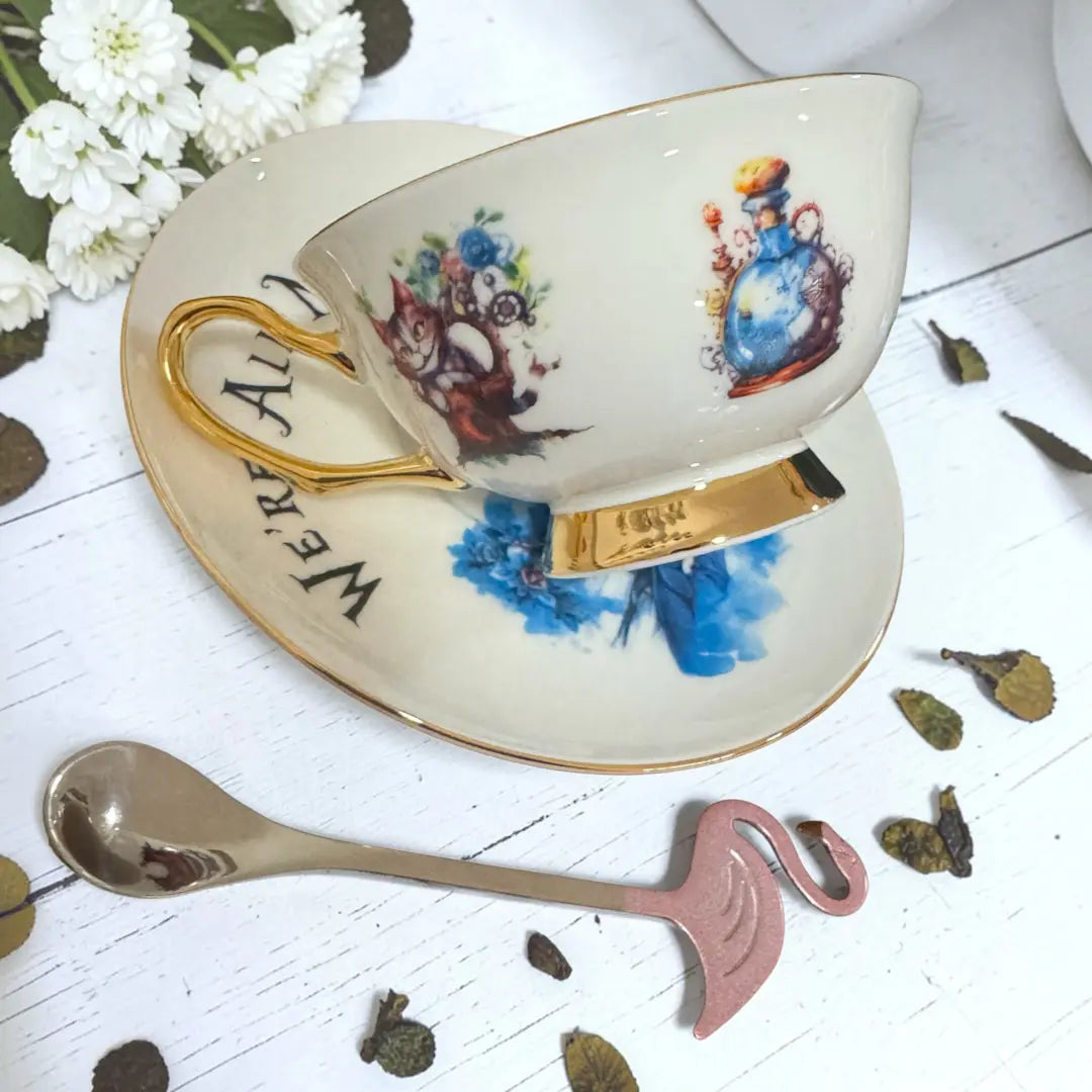 Alice teacup side view with the Cheshire Cat beside the clockwork Drink Me potion bottle, and 24ct gold handle