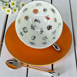 White interior of the teacup showing colourful tarot and fortune telling symbols like the Wheel of Fortune, Tower, and Death.