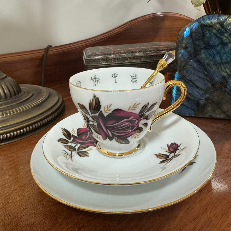 Floral teacup and saucer set on a wooden surface with decorative elements.