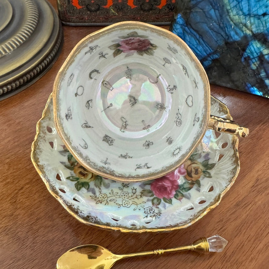 Decorative teacup and saucer with floral patterns on a wooden surface.
