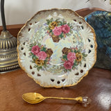 Decorative plate with floral design and a gold spoon on a wooden surface
