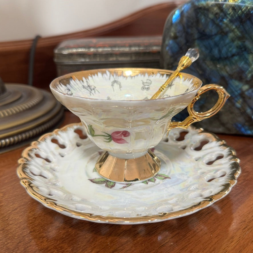 Decorative teacup with floral design and gold accents on a matching saucer.