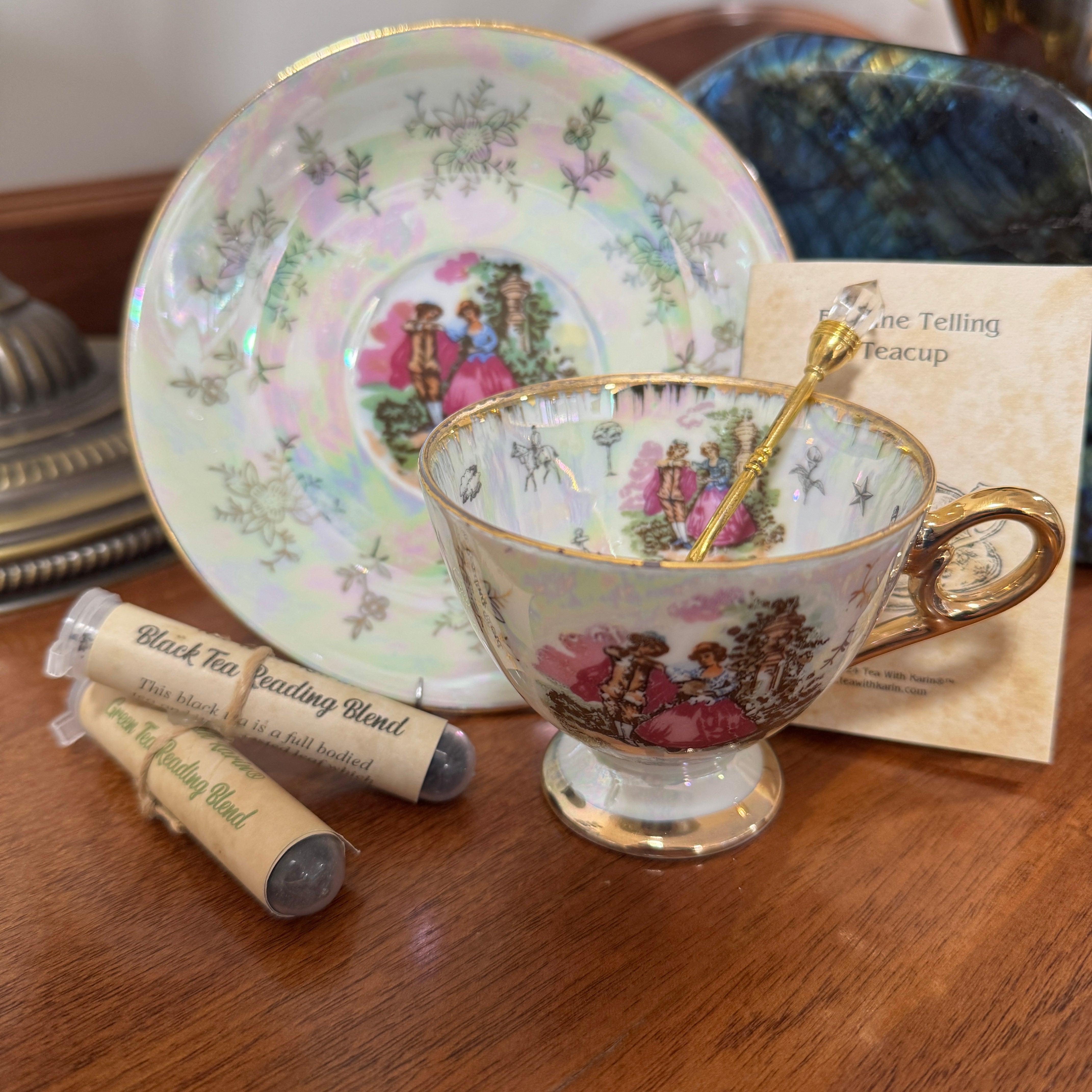 Decorative teacup with saucer and tea packaging on a wooden surface