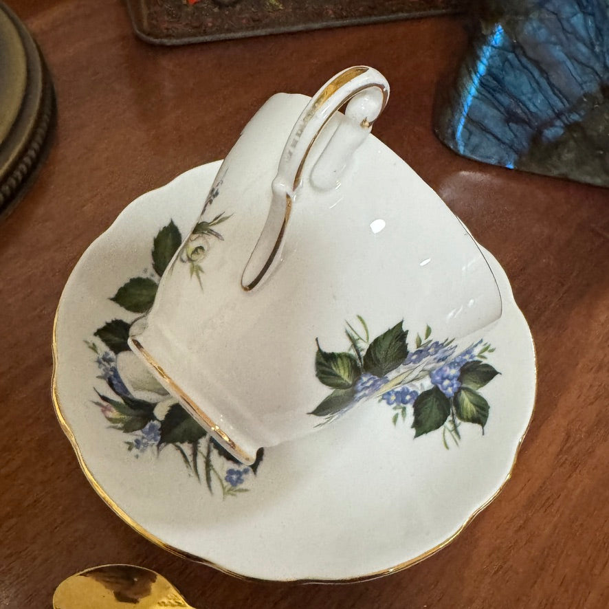 Teacup and saucer with floral design on a wooden surface