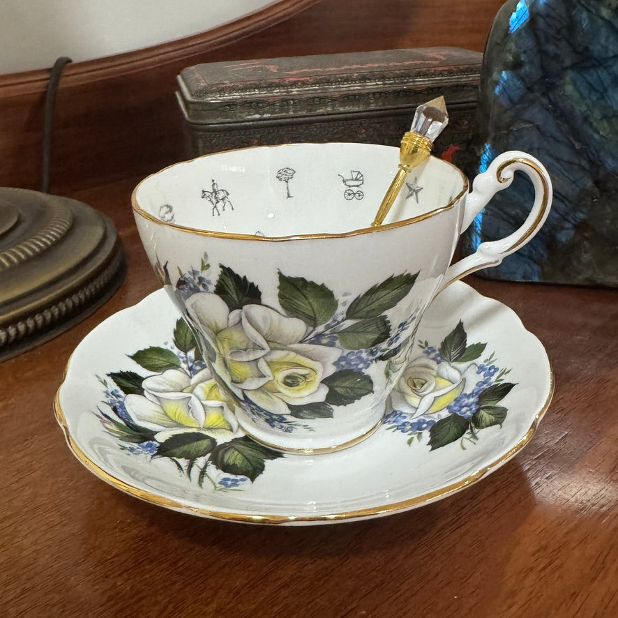 Teacup and saucer with floral design on a wooden surface