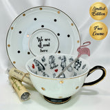 Complete set of the Alice in Wonderland 'We are all mad here' tea cup and saucer with gold and black polka dots, pink flamingo stirring spoon, and two sample tea vials.