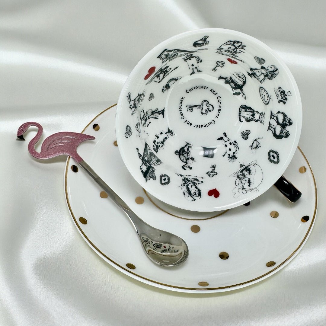 Detailed view of the interior of the Alice in Wonderland tea cup, showing the black and white illustrations of characters like the Mad Hatter and the Queen of Hearts.