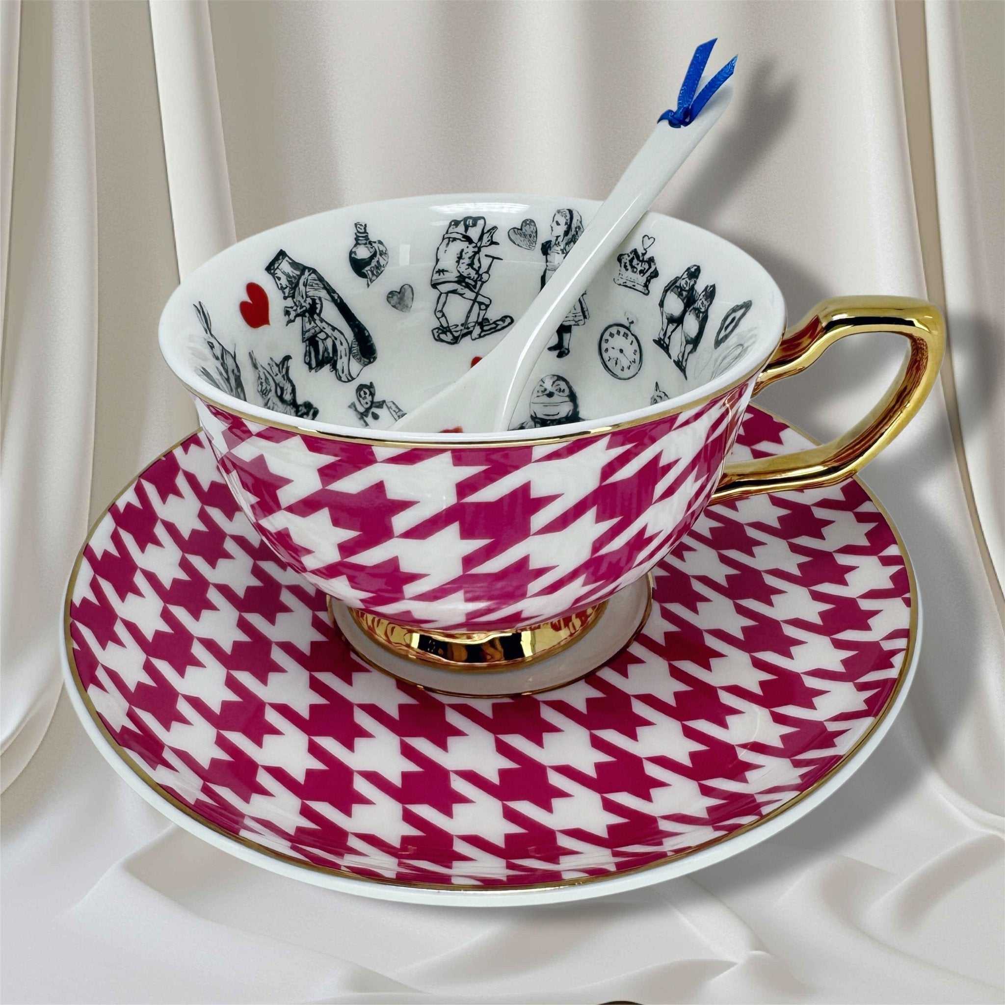 White and pink houndstooth teacup with gold trim and fortune telling symbols inside, on a magenta saucer.