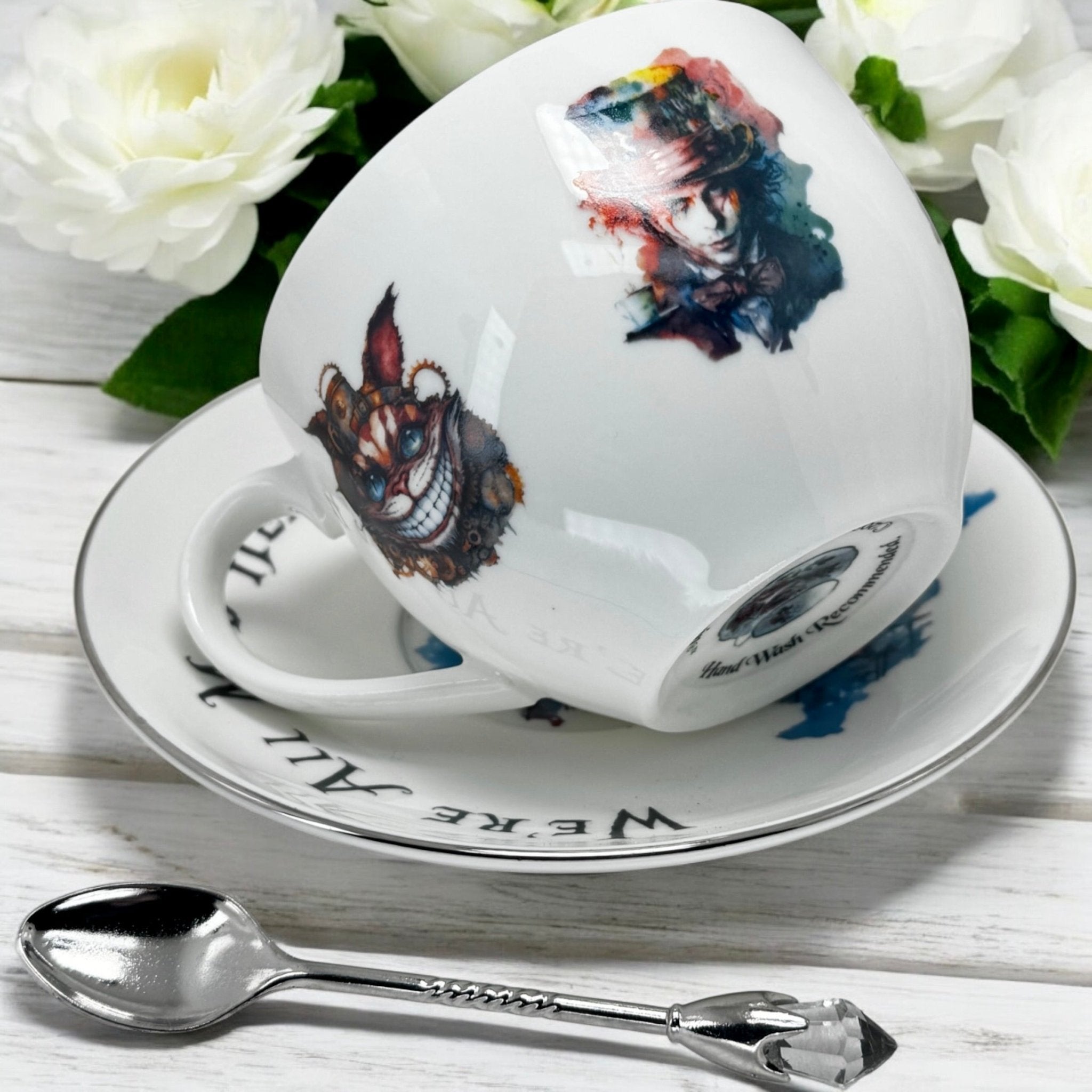 Alice in Wonderland  for Fortune telling tea cup and saucer with character designs on a white surface with flowers in the background