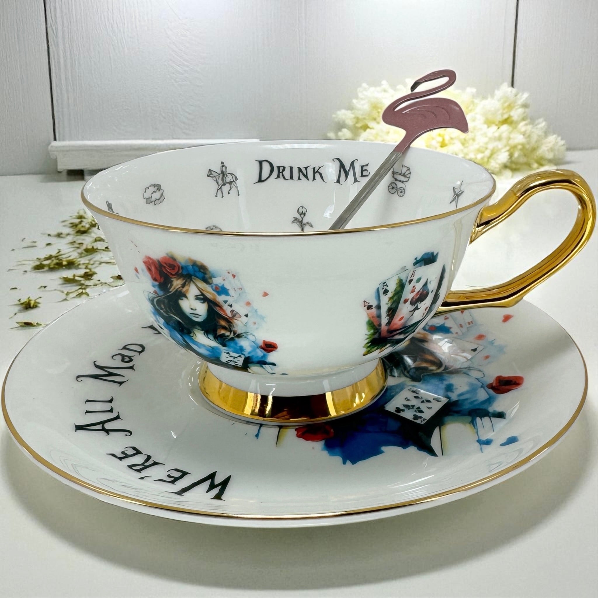 Teacup with 'Drink Me' and 'We Are All Mad Here' text on a white background