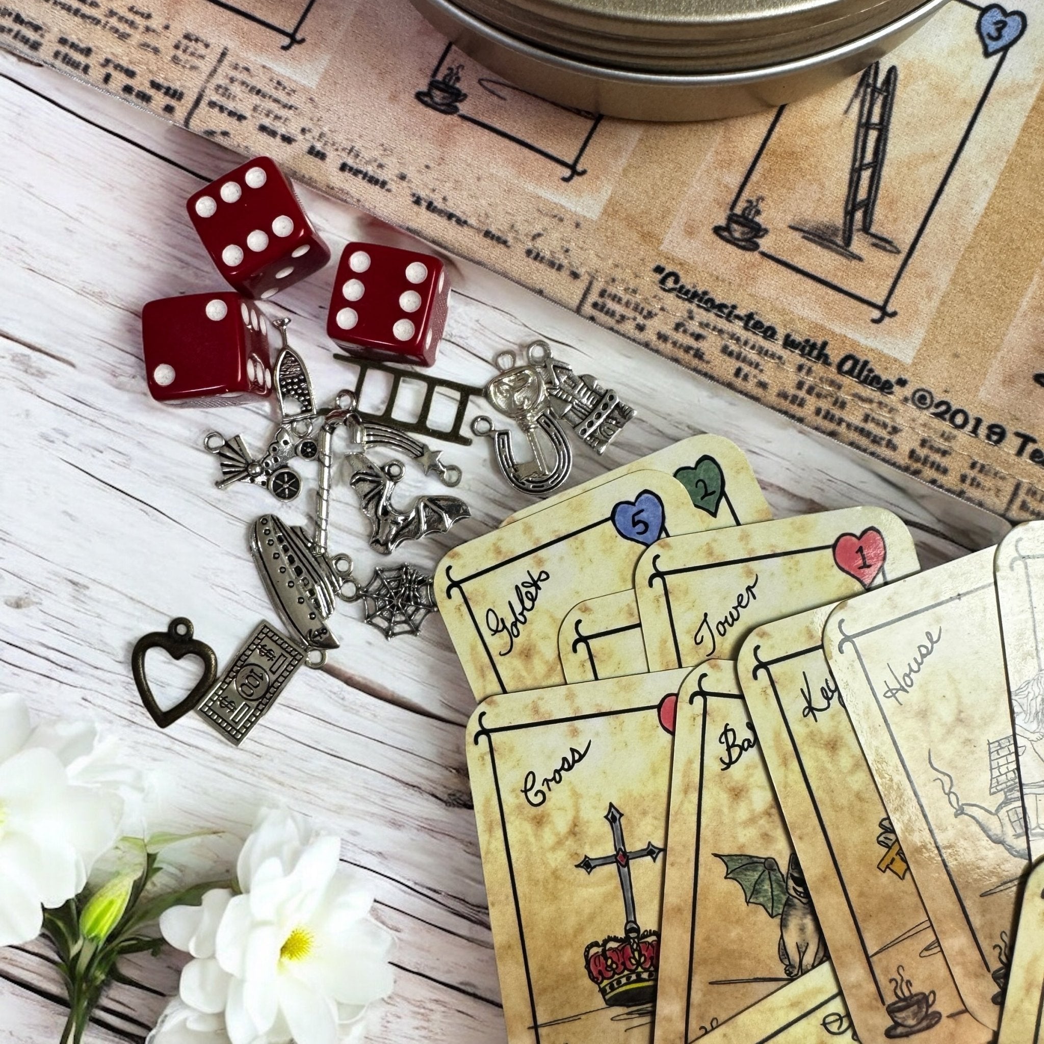 This is a unique divination system all in one tinned kit.  It is based upon tea leaf reading and Alice in Wonderland theme. It has a washable spandex mat and 18 mini cards and 18 charms and 3 dice.