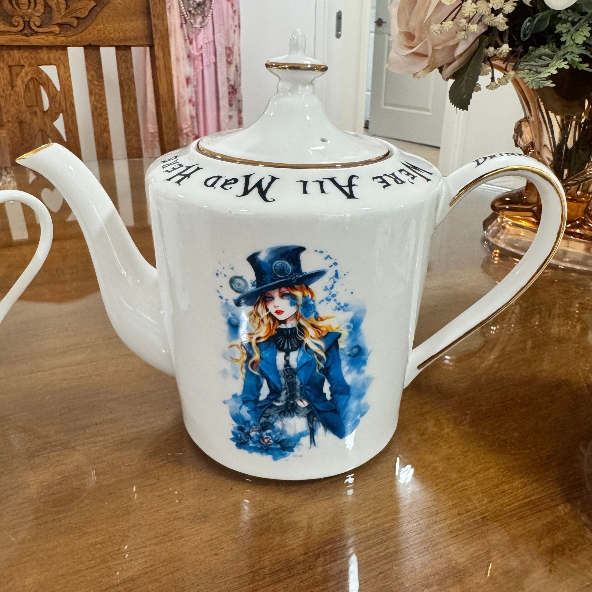 White teapot with a decorative design on a wooden table