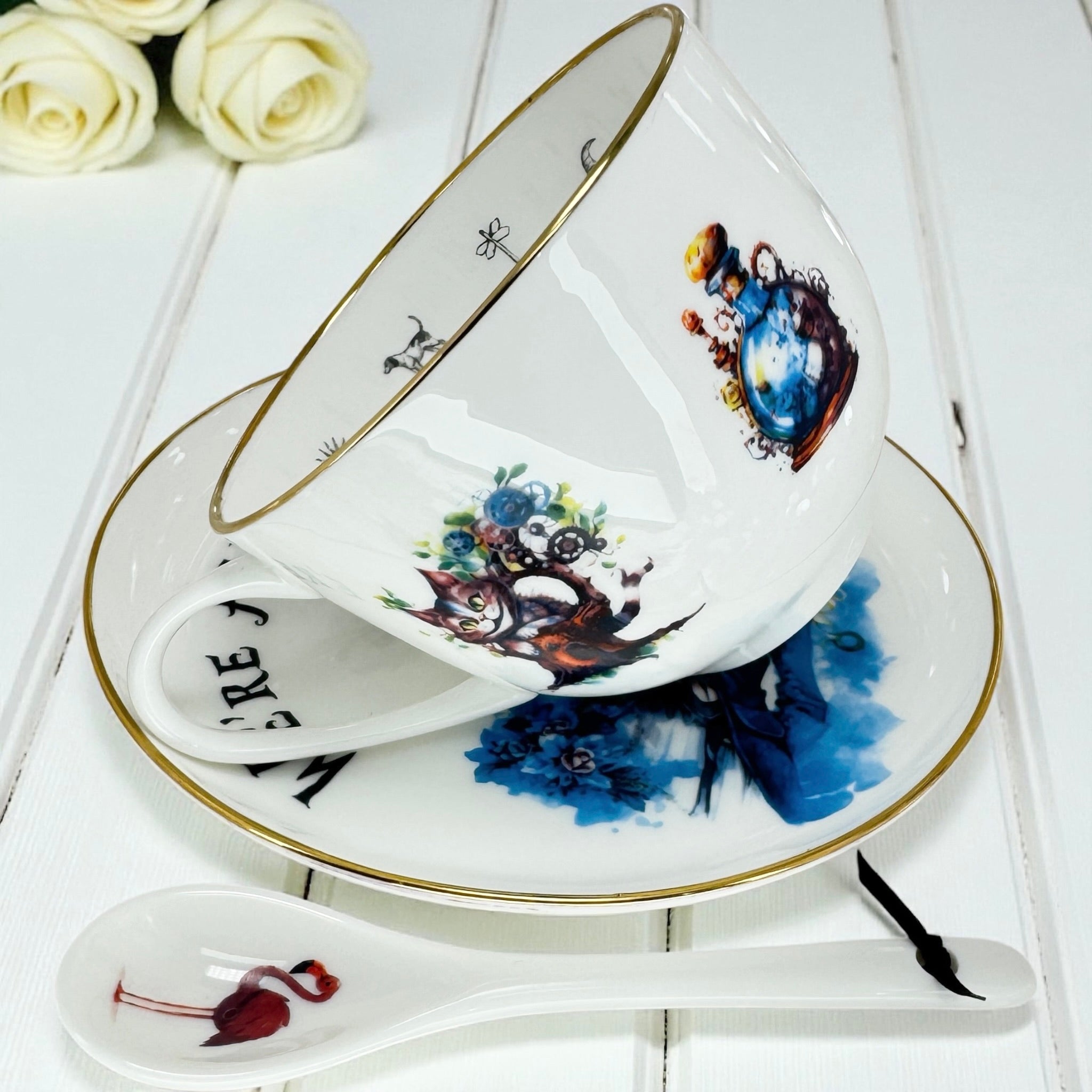 Angled view of the teacup showcasing the Cheshire Cat illustration on the side and gold detailing.