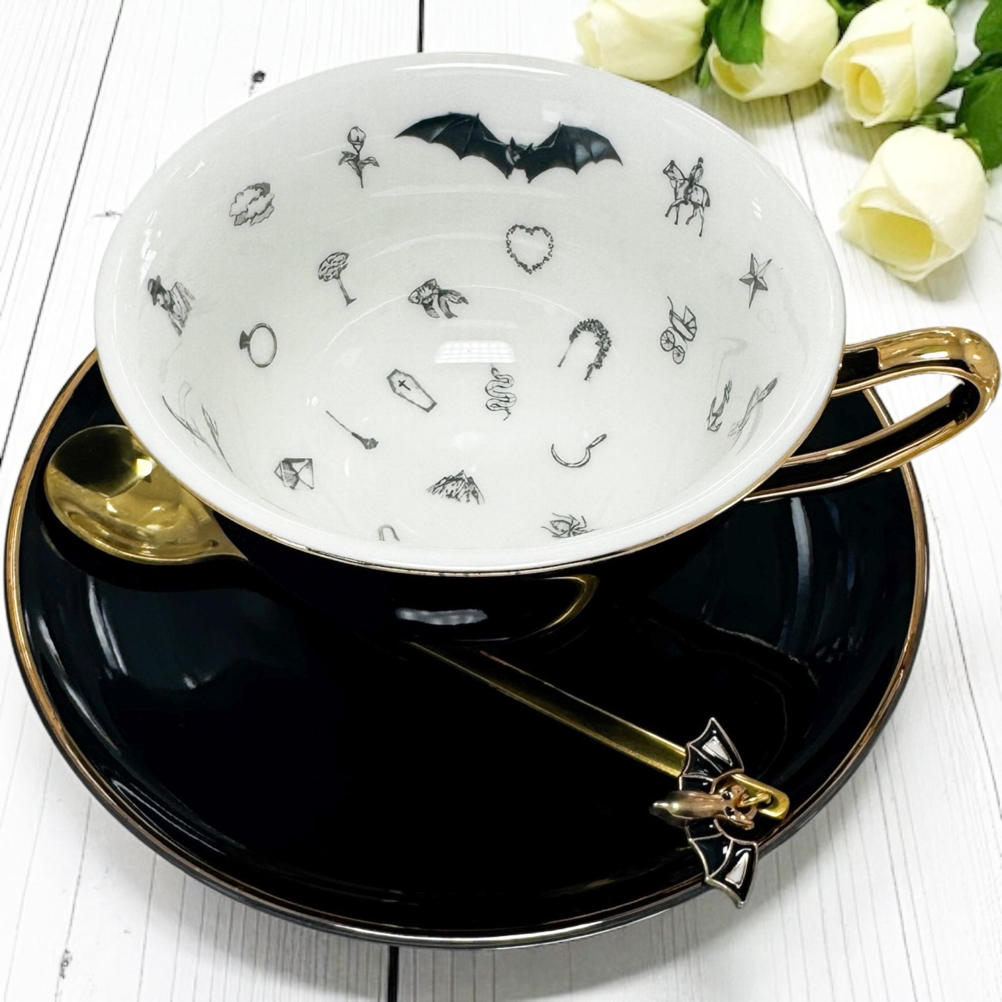 Ceramic teacup with black bat design on a white background
