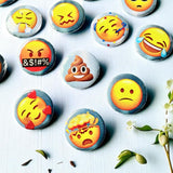 Close-up of emoji charm casting coins showing individual emoji designs