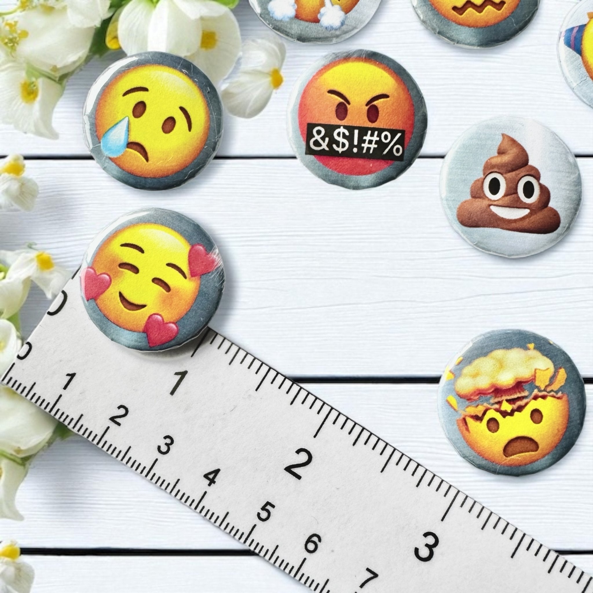 Close-up of Emoji divination coins showing assorted emoji designs for charm casting