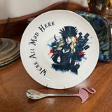 Gothic Alice saucer with feathered top hat, tarot cards and We're All Mad Here lettering, with pink flamingo teaspoon
