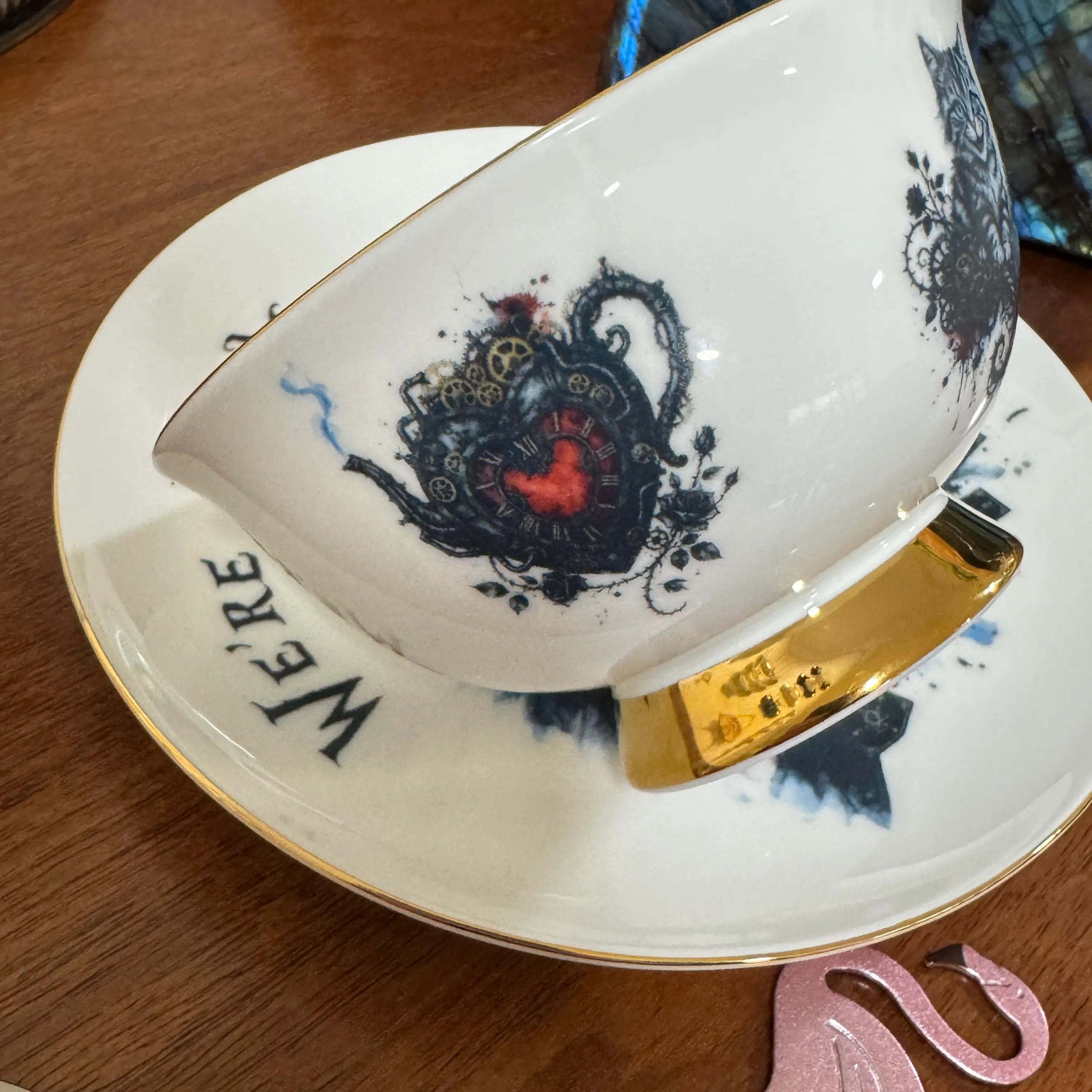 Clockwork heart teapot artwork above the 24ct gold foot of the gothic Alice teacup
