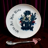 Gothic Alice saucer with top hat, tarot cards and We're All Mad Here lettering, with pink flamingo teaspoon