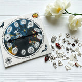 Collection of Halloween-themed charms on a white surface with a decorative box and flowers