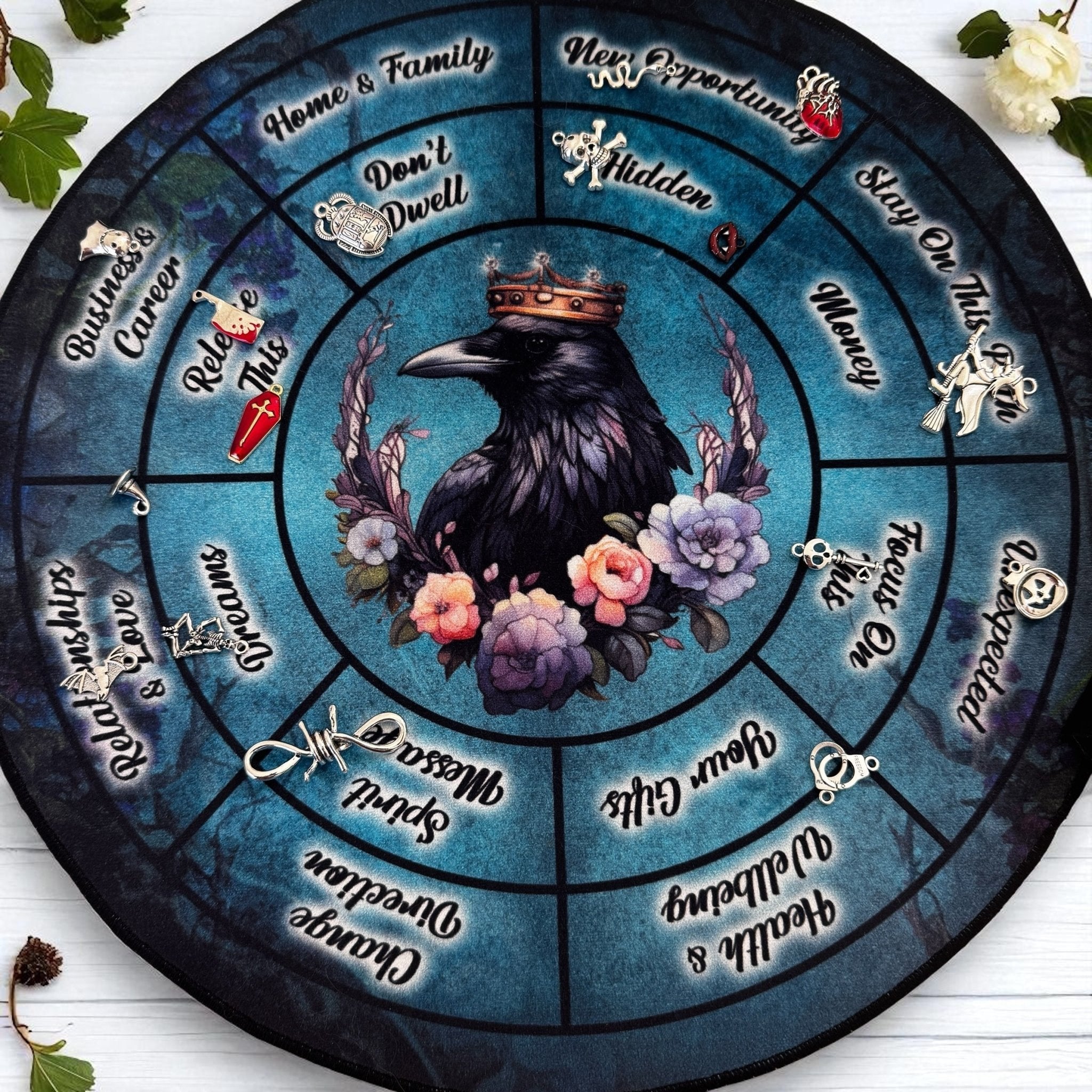Velvet charm casting mat with a crow, flowers, and various phrases on a blue background