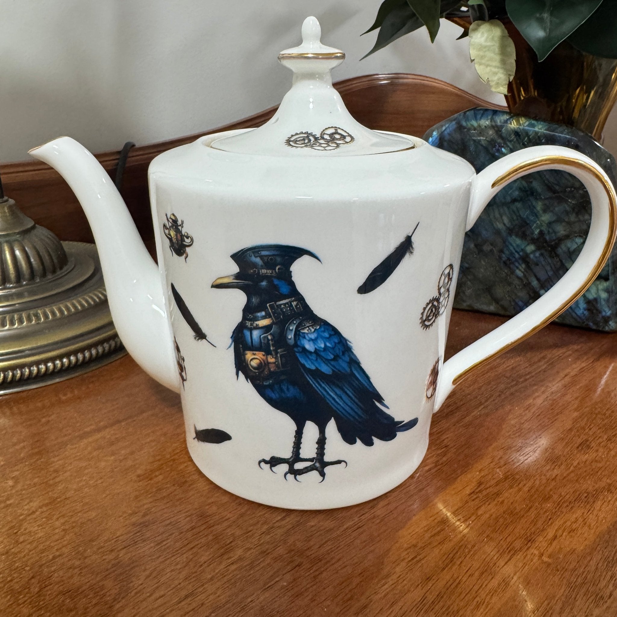 Steampunk Crow Tea Party Set — 24CT gold raven teapot left side view with steampunk crow design on wooden surface | Tea Leaf Reader