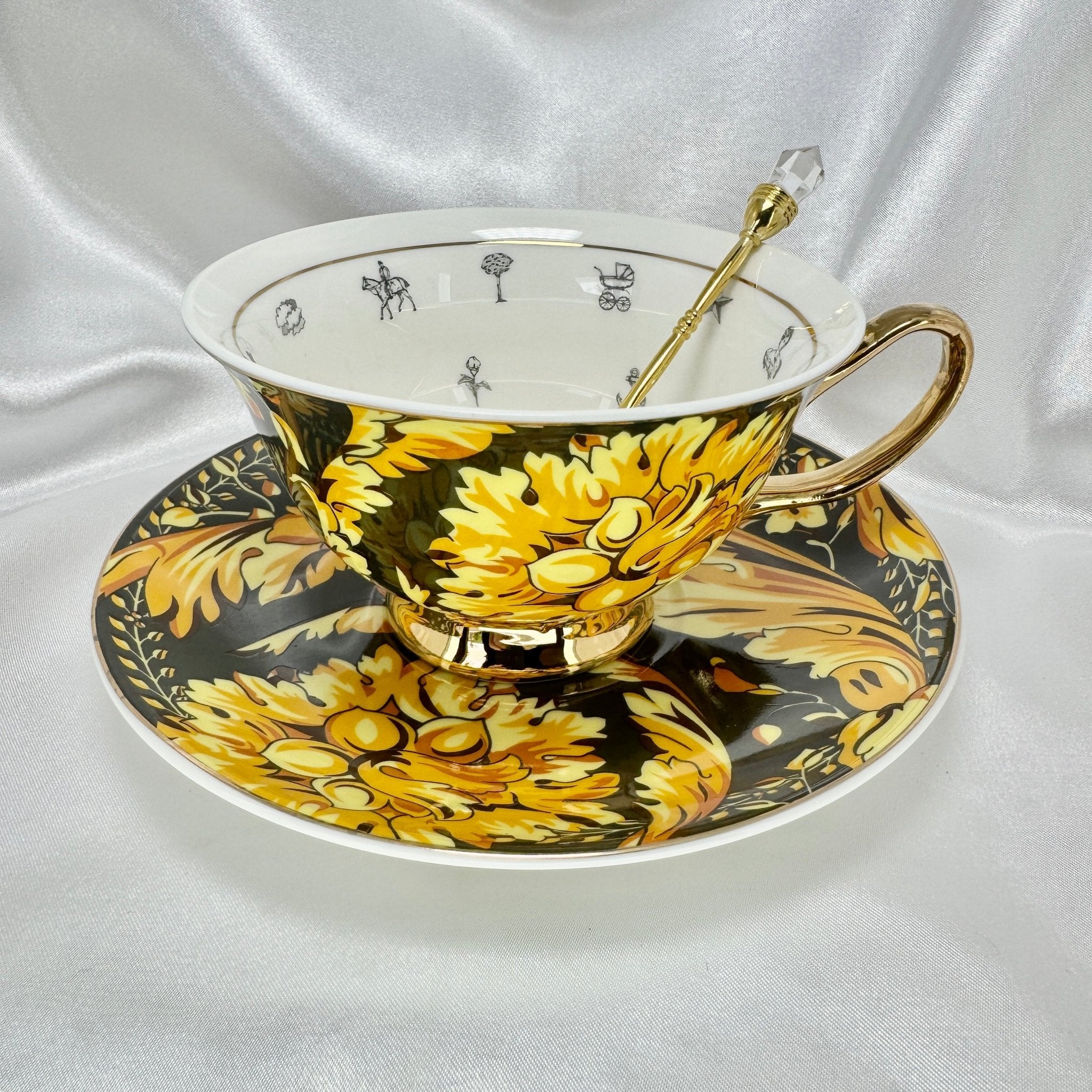 Front view of the black and gold patterned teacup with gold spoon and fortune telling symbols inside
