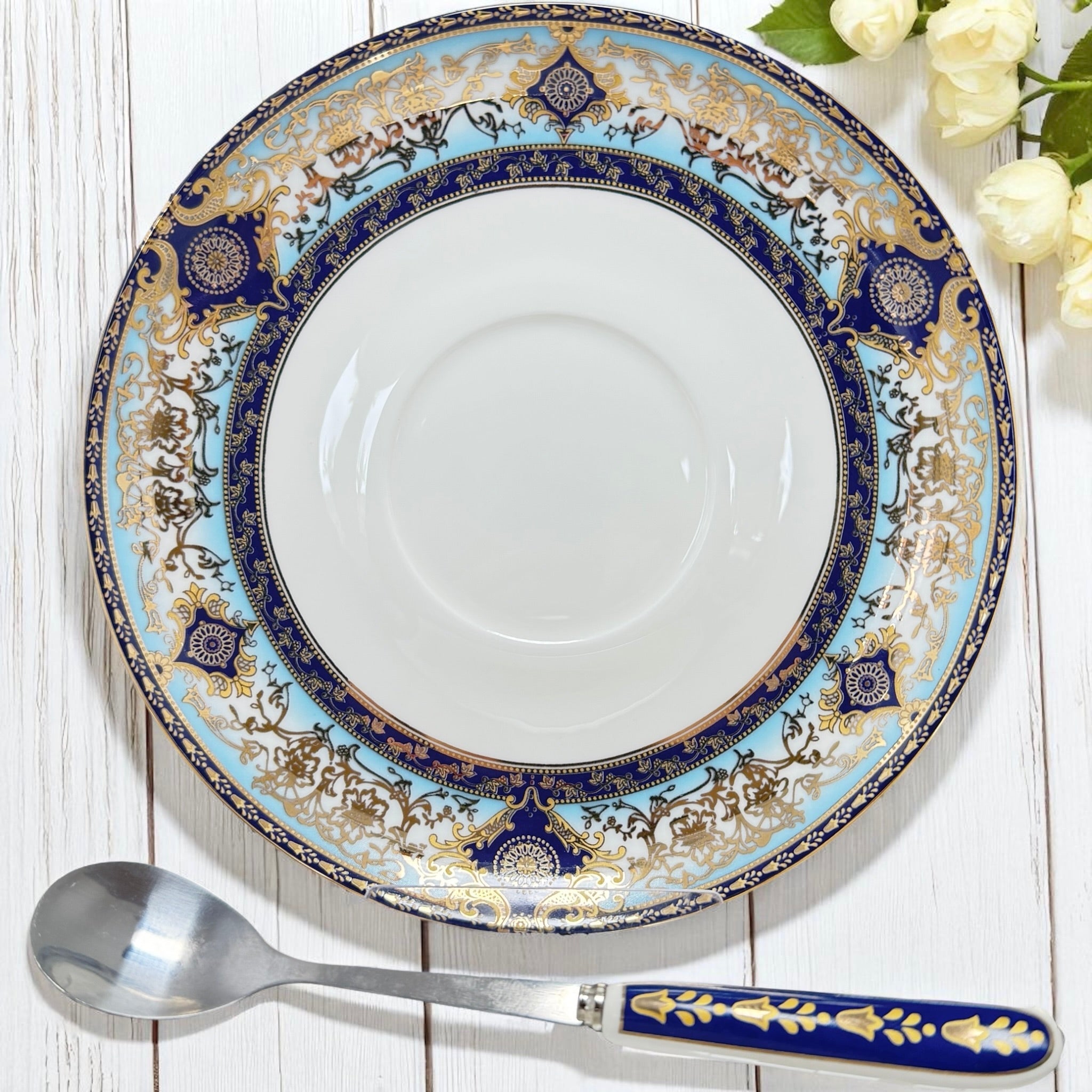 Close-up view of the intricate gold detailing on the rim of the elegant Persian divination saucer.