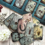 Discover the Curiosi-Tea Oracle Kit – a compact and enchanting tool for tea leaf divination. This unique set includes 18 thoughtfully designed cards, each adorned with symbolic imagery to guide your readings. Accompanied by a selection of charms, the kit offers a tactile dimension to your divination practice. Housed in a sleek gold tin, it’s perfect for on-the-go insights or intimate sessions at home. 