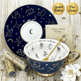 Navy blue tarot tea leaf reading teacup with gold accents, featuring star constellations, on a wooden surface with packaging and tea leaves.