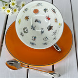 White interior of the teacup showing colourful tarot and fortune telling symbols like the Wheel of Fortune, Tower, and Death.