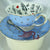 Video of the blue polka dot teacup and saucer rotating, highlighting the full Alice in Wonderland illustrations inside and the 'Curiouser and Curiouser' text.